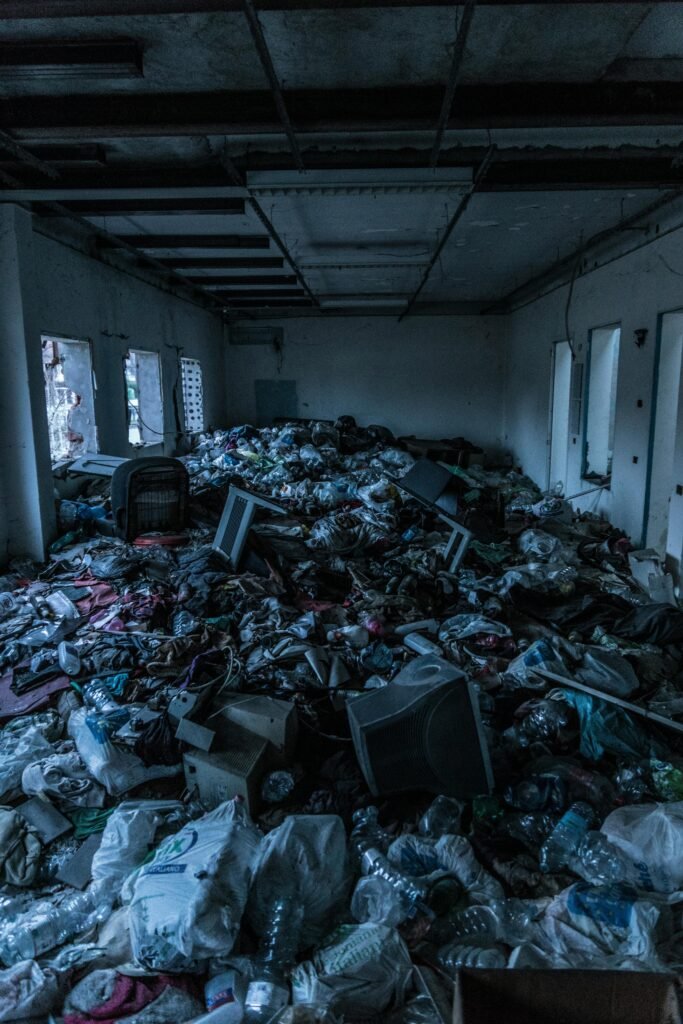 pexels-photo-938044-938044-1 Decrepit indoor room cluttered with heaps of garbage and waste materials.